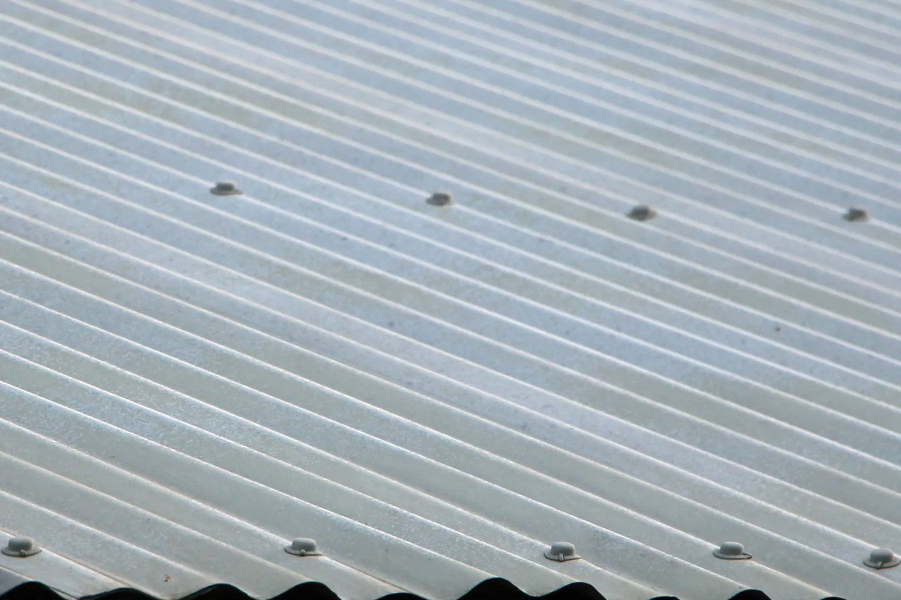 Close-up of weathered corrugated asbestos-cement roof sheeting